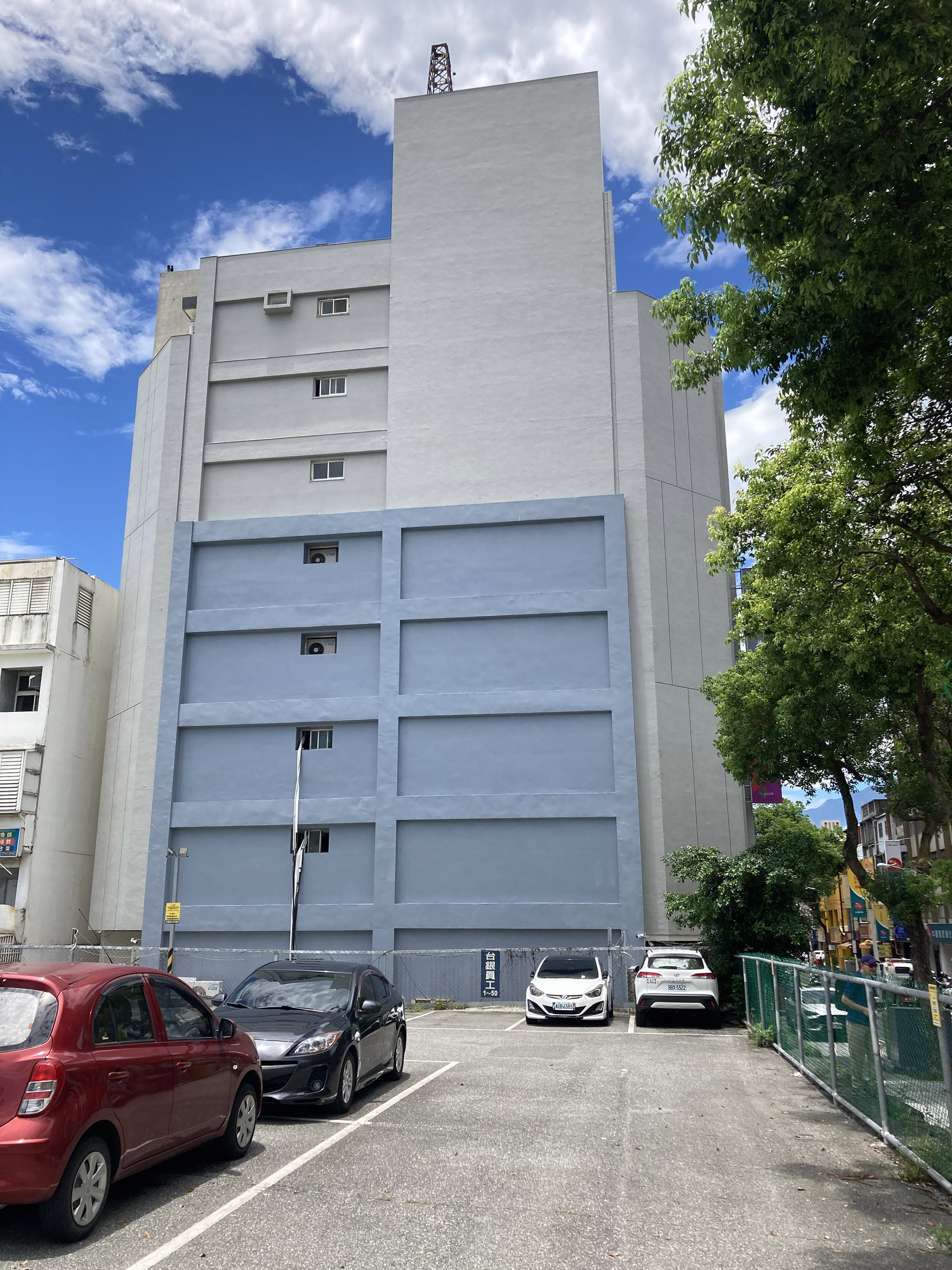 exemple d'un bâtiment (banque) renforcé depuis le séisme de 2018. coté rue, les poteaux sont renforcés par une structure métallique, sur le pignon, un chemissage de sportiques est visible. le bâtiment ne présente pas de dommage à la structure.